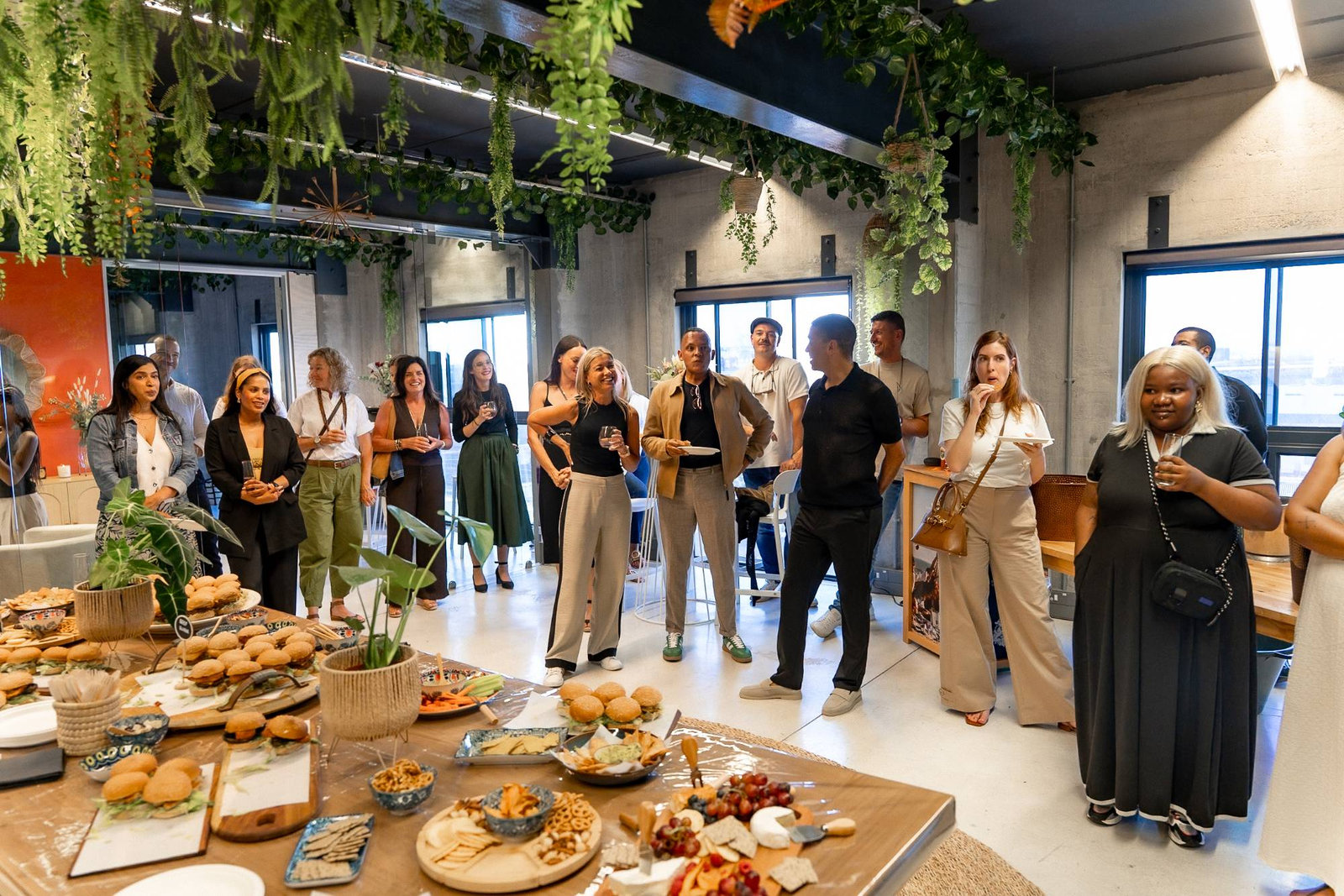 Guests mingling at an Ivie Media event beneath hanging greenery