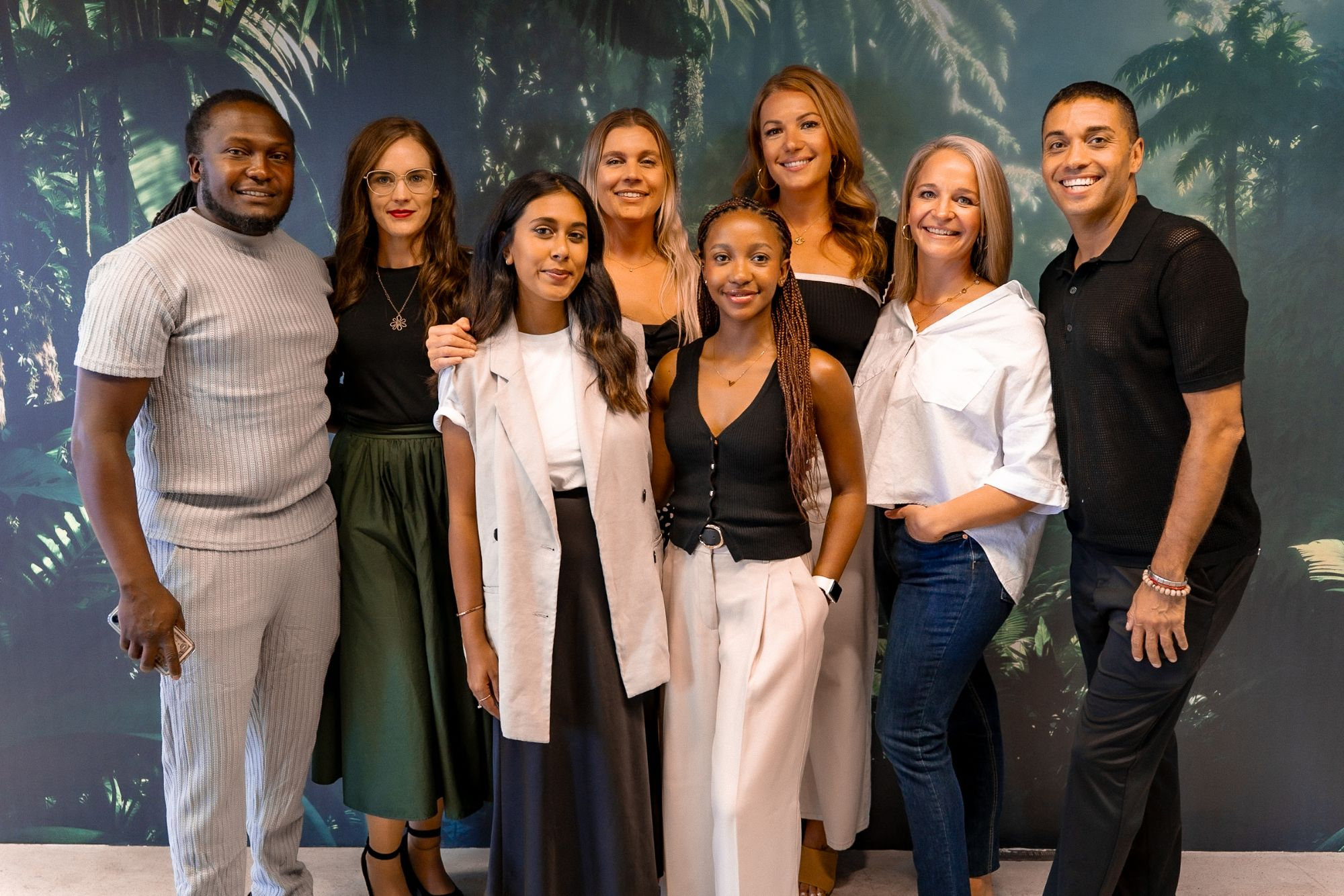 The Ivie Media team standing together in front of a tropical backdrop